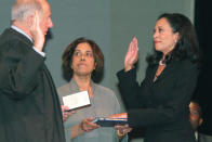 FILE - In this Jan. 8, 2004, file photo, San Francisco's new district attorney, Kamala Harris, right, receives the oath of office from California Supreme Court Chief Justice Ronald M. George, left, during inauguration ceremonies Thursday, Jan. 8, 2004, in San Francisco, as Harris' mother, Dr. Shyamala Gopalan, holds a copy of "The Bill of Rights." (AP Photo/George Nikitin, File)