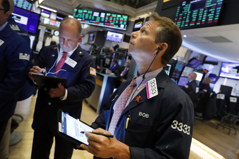 Traders Michael Urkonis, left, and Robert Charmak work on the floor of the New York Stock Exchange, Wednesday, Sept. 4, 2019. Stocks are opening higher on Wall Street following big gains in Asia as Hong Kong's government withdrew a controversial extradition law that set off three months of protests there. (AP Photo/Richard Drew)