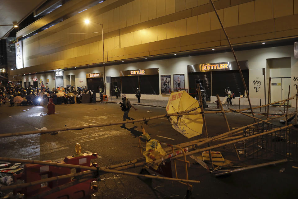 A photo journalist run past bamboo sticks and barricades set up by protesters to block a road during a protest in Hong Kong, Sunday, July 28, 2019. Police fired tear gas at protesters in Hong Kong on Sunday for the second night in a row in another escalation of weeks-long pro-democracy protests in the semi-autonomous Chinese territory. (AP Photo/Vincent Yu)