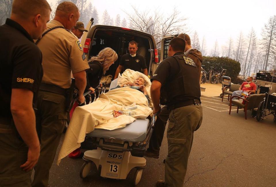 Hospital workers and first responders evacuate patient from Feather River Hospital on Nov. 8 in Paradise, California, during Camp Fire