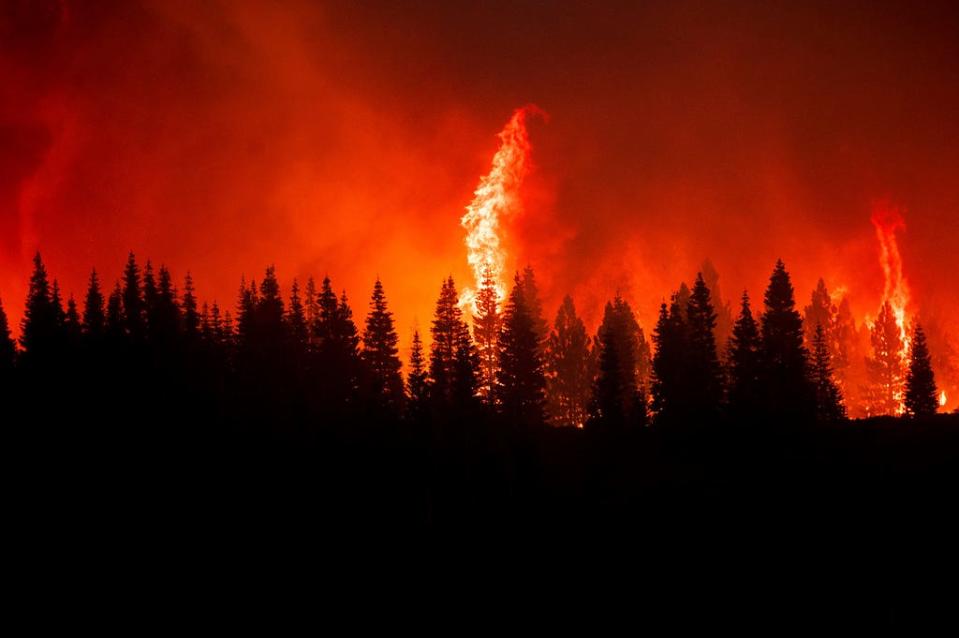 Flames from the Dixie Fire crest a hill in Lassen National Forest, Calif., near Jonesville on Monday, July 26, 2021.