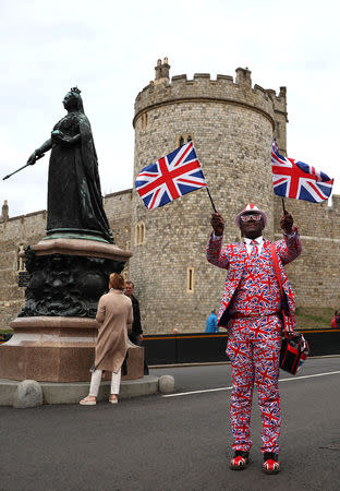 A royal fan waves flags outside the castle walls, on the day before the royal wedding of Britain's Princess Eugenie and Jack Brooksbank, in Windsor, Britain, October 11, 2018. REUTERS/Hannah McKay