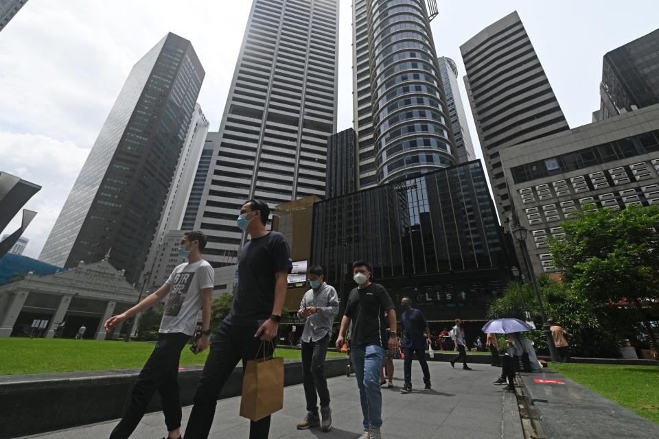 At Raffles Place in Singapore, office workers go on strike during their lunch break, illustrating an example of flexible working arrangements such as working from home.