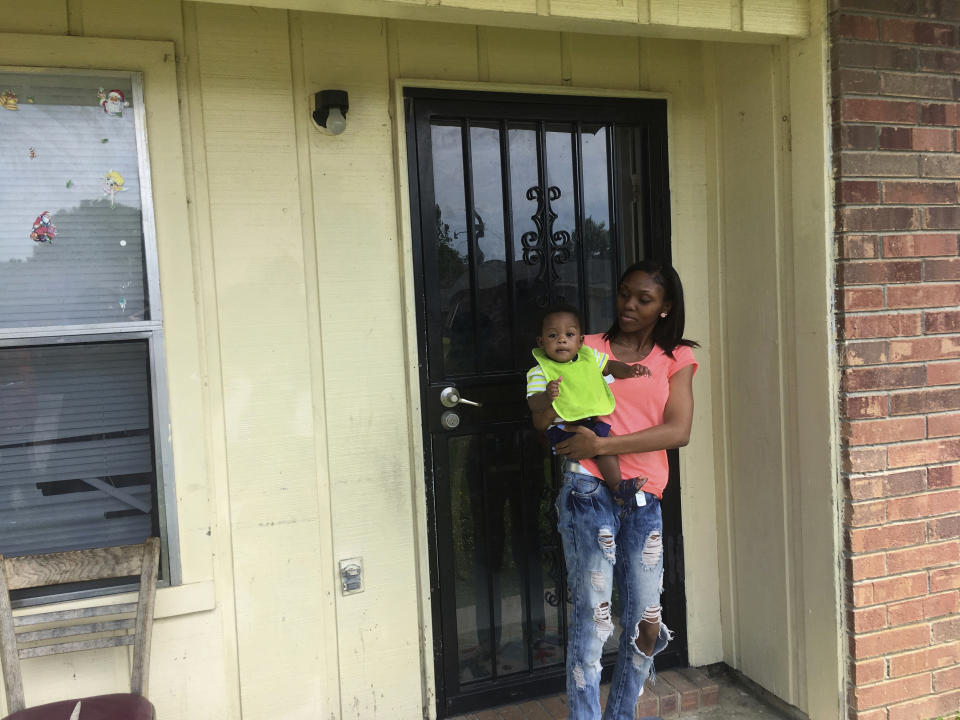 FILE - In this May 9, 2018, file photo, Starr Jones, 21, stands outside her Shelby, Miss., apartment with her 9-month-old son, Jarvis Kemp, after talking with the nonprofit group Save the Children about her community work to fight poverty. A Save the Children report released Tuesday, June 2, 2020, says childhood disparities around malnutrition, graduation rates, and early deaths are worst in the U.S. among rural, black-majority counties in the American South and isolated counties with Native American populations. (AP Photo/Russell Contreras, File)