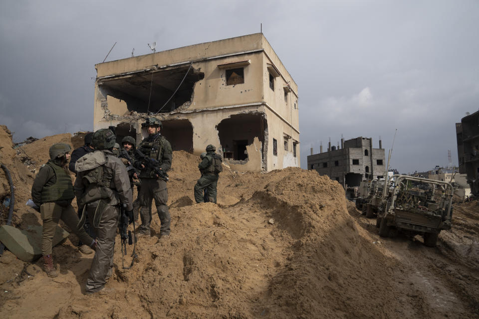 Israeli soldiers stand outside a building during the ground offensive on the Gaza Strip in Khan Younis, Saturday, Jan. 27, 2024. (AP Photo/Sam McNeil)