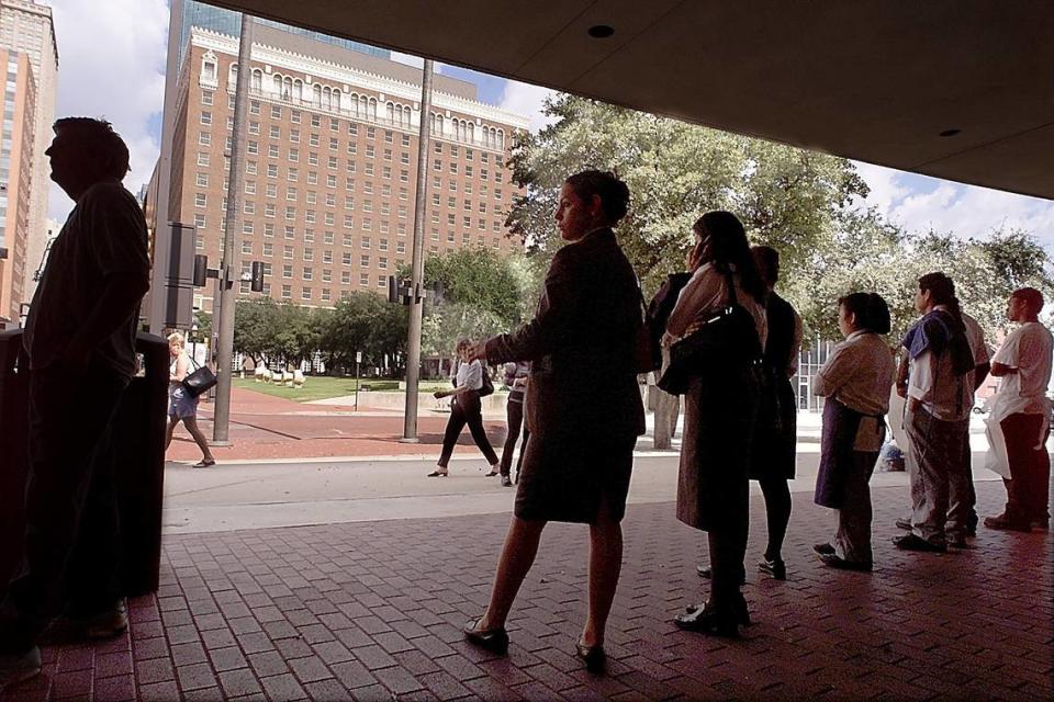 Guests and employees from the Radisson Hotel seek shelter in the shade of the Fort Worth Convention Center in downtown Fort Worth on Sept. 11, 2001. The hotel was evacuated due to bomb threats after terrorists destroyed the World Trade Center and damaged the Pentagon.