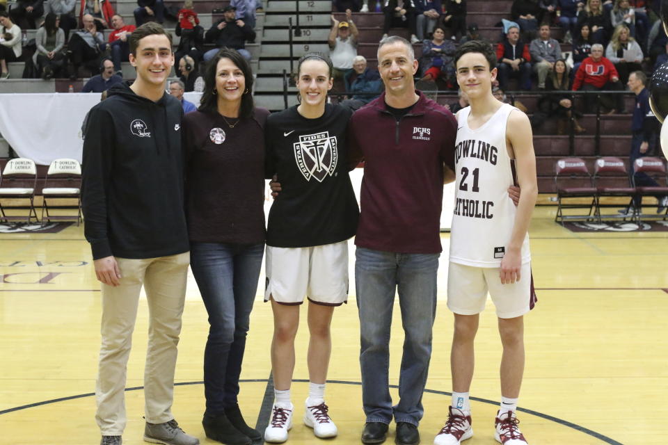 This photo provided by Dowling Catholic High School shows basketball player Caitlin Clark, center, posed with family members, from left; brother Blake, mother Anne Nizzi-Clark, Caitlin, father Brett Clark, and brother Colin during senior night on the day of the last game of the season, Feb. 7, 2020, at Dowling Catholic High School in West Des Moines, Iowa. (Earl Hulst/Dowling High School via AP)