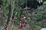 Malaysian emergency services personnel work to rescue passengers after a bus carrying tourists and local residents fell into a ravine near the Genting Highlands, about an hour's drive from Kuala Lumpur on August 21, 2013. At least 20 dead bodies have been recovered