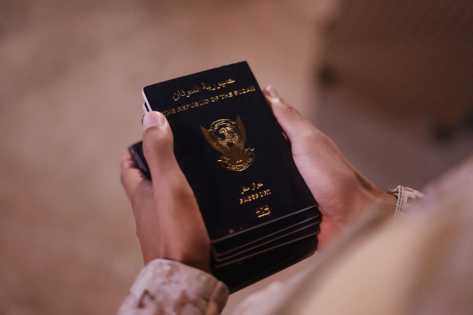 A Saudi commando carries dozens of Sudanese passports for evacuees at Port Sudan before boarding a Saudi military ship to Jeddah port, late Tuesday, May 2, 2023. Exhausted Sudanese and foreigners joined growing crowds at Sudan's main seaport Tuesday, waiting to be evacuated from the chaos-stricken nation. After more than two weeks of fighting, areas of the capital of Khartoum appear increasingly abandoned. (AP Photo/Amr Nabil)