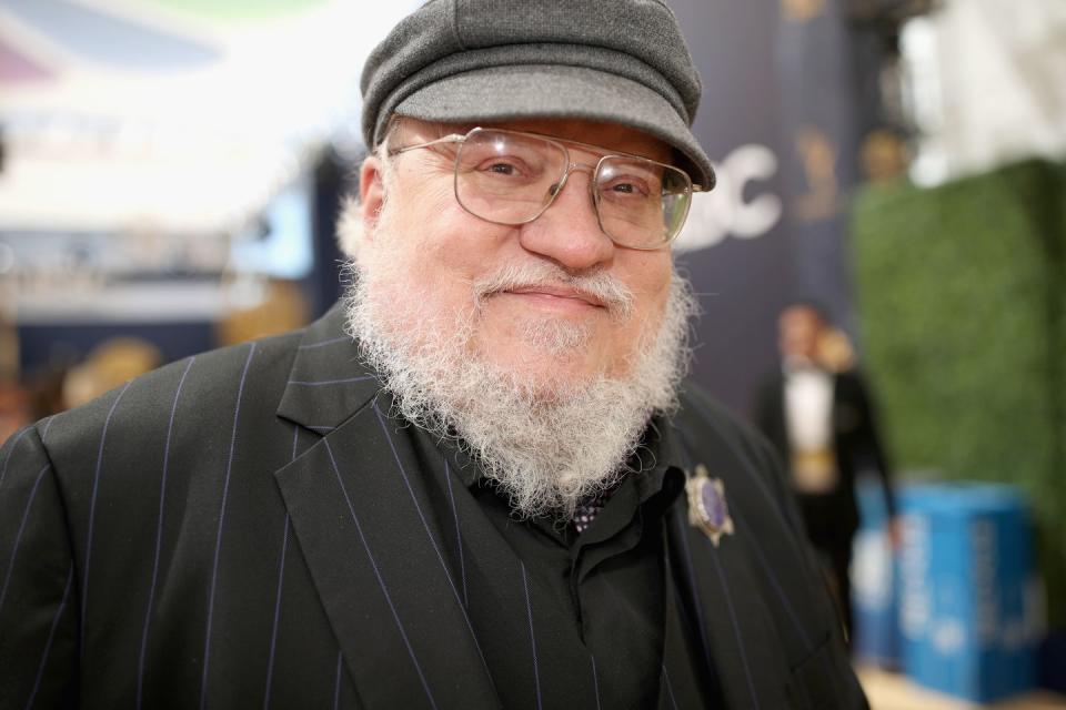 <p>George R R Martin was born in Bayonne, New Jersey. His writing career started with convincing another person to write –– English professor George Guthridge, who notoriously despised Sci-fi and fantasy. Martin persuaded him to give speculative fiction a second look, and Guthridge even made an effort to write it himself; he was rewarded with a finalist nom for the Hugo and Nebula Awards. In turn, Guthridge was able to help Martin find a job at Clark University, since his short stories weren’t making enough money for him to live off of. He worked in tv for a while, but was so frustrated with the limitations of it that he returned to novels, and in 1991, penned<em> A Song of Ice and Fire</em>. The book, and the subsequent <em>The Game of Thrones</em> series novels were explosive, becoming international bestsellers, and spawning an HBO adaptation. The series would go on to win numerous awards, and in turns delight and frustrate fans of both the book series and the tv adaptation. With two more novels planned in the series, people are still waiting for him to conclude the story. </p>