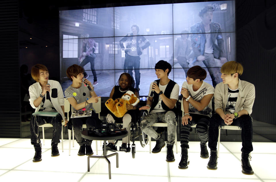 Donika Sterling from New York, third left, talks with members of South Korean pop group SHINee in Seoul, South Korea, Wednesday, June 20, 2012. The 15 year-old American K-pop fan, who is suffering a disease that gradually causes loss of muscle tissue and slows down parts of the body, met and sang with the boy band she idolizes. (AP Photo/Lee Jin-man)
