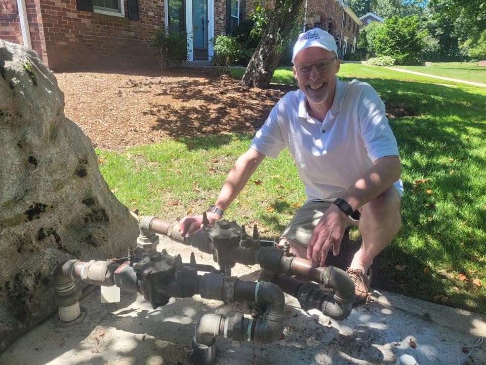 Duncan Fuller, president of the Windsor Green Board of Trustees, poses outside the main water main at the Windsor Green condominium complex in Framingham. Residents there believe they have been overcharged in recent months for water use.