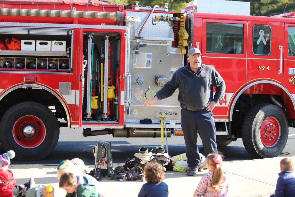 Deputy Chief Ferrante of Bernardsville Fire Department explains how much clothing and equipment firefighters need to wear to keep them safe to the Far Hills Country Day School Preschool group of 2 1/2 and 3-year-olds.