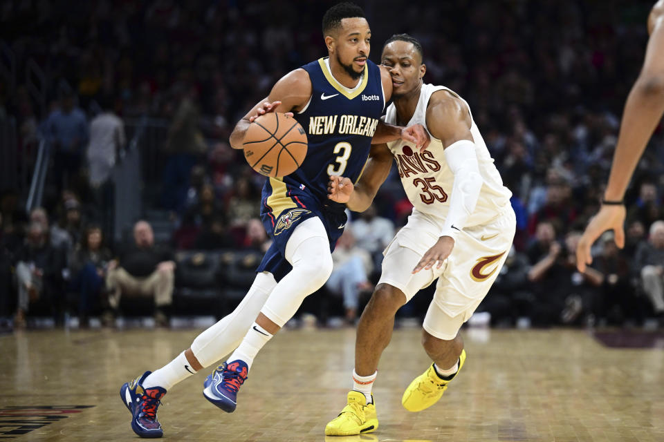 New Orleans Pelicans guard CJ McCollum (3) drives against Cleveland Cavaliers forward Isaac Okoro (35) in the second half of an NBA basketball game, Thursday, Dec. 21, 2023, in Cleveland. (AP Photo/David Dermer)