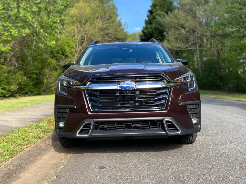The Ascent's front end features a large blacked grille with a prominent chrome bar and Subaru logo protruding out.