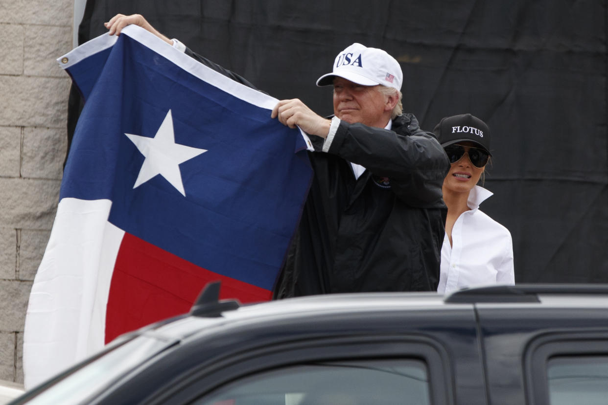 President Trump, accompanied by first lady Melania Trump, holds up a Texas flag on Tuesday after speaking with supporters in Corpus Christi, Texas, where he received a briefing on Hurricane Harvey relief efforts. (Photo: Evan Vucci/AP)