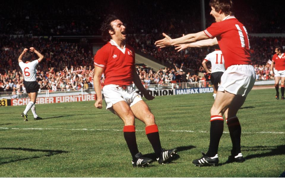 Lou Macari celebrates his winning goal with Gordon Hill (right) in the 1977 FA Cup final - ‘The most important thing is City don’t do the Treble’ – Man Utd’s class of ’77 on FA Cup final - Colorsport/Shutterstock