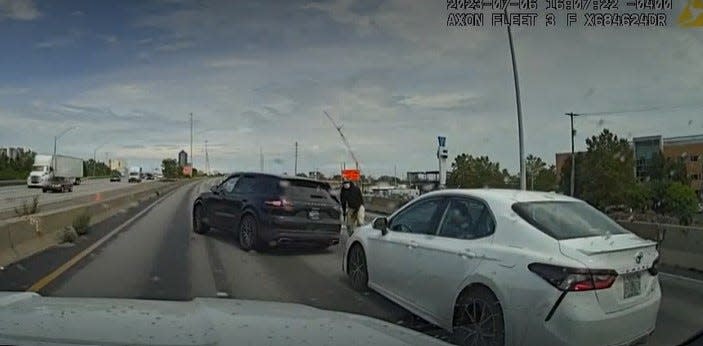 A still image taken from a dashcam video Columbus police released Sept. 12 shows one of three suspects standing outside a stolen Porsche SUV in the middle of Interstate 70 east near West Mound Street during a July 6 police chase following an armed bank robbery.