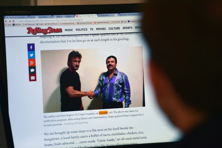 A man reads an article about drug lord Joaquin "El Chapo" Guzman on the website of Rolling Stone magazine, showing a picture of him (R) and US actor Sean Penn, in Mexico City on January 10, 2016