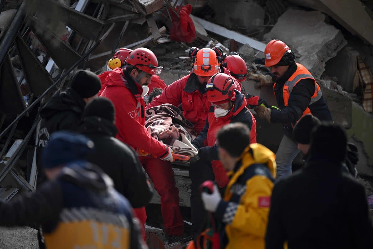 Rescue personnel carry a rescued young man on a strecher through the rubble of buildings in kahramanmaras, the quake’s epicentre, after a 7.8-magnitude earthquake struck the country’s southeast (AFP via Getty Images)