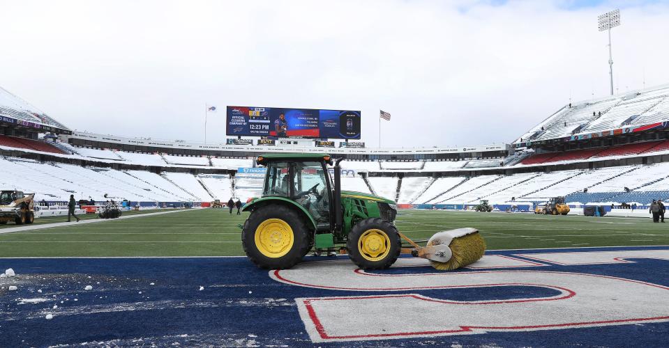 A tractor clears snow from the field at Highmark Stadium before the playoff game against Pittsburgh.