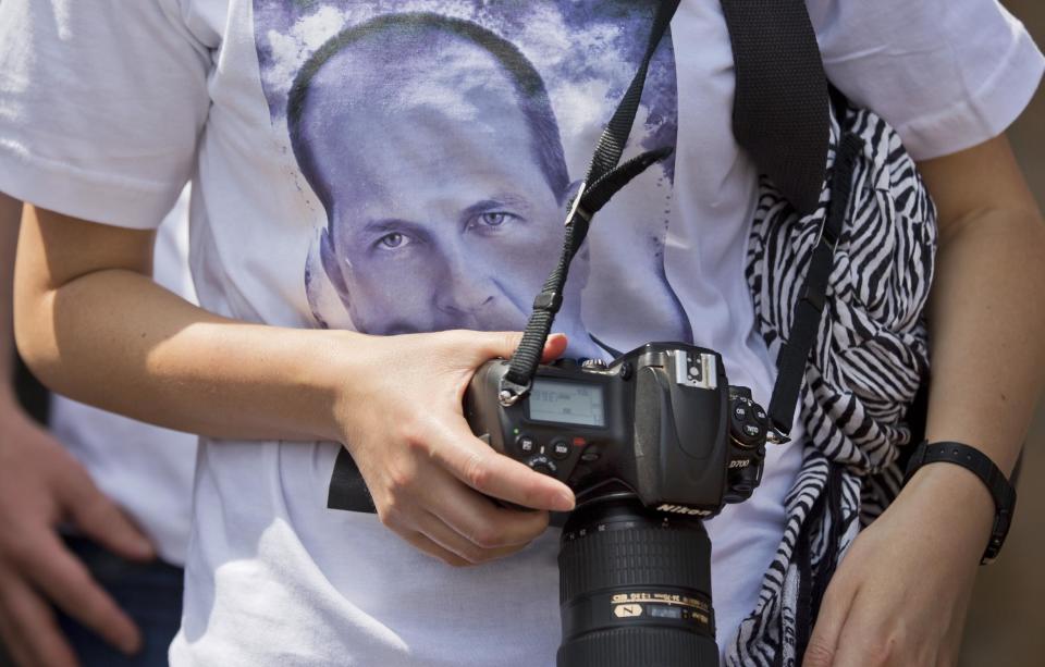 A photojournalist wears a tee-shirt showing the face of detained Al-Jazeera journalist Peter Greste at a demonstration by Kenyan and Nairobi-based foreign media calling for the release of Greste and his colleagues, outside the Egyptian embassy in Nairobi, Kenya Tuesday, Feb. 4, 2014. Nairobi-based correspondent Greste was taken into custody in Egypt on Dec. 29 and is among 20 journalists working for Al-Jazeera, including four foreigners, who will face trial there on charges of joining or aiding a terrorist group and endangering national security - an escalation that raised fears of a crackdown on freedom of the press. (AP Photo/Ben Curtis)