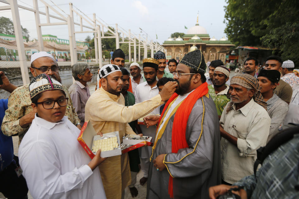 Indian Muslims feed sweets to each other after the Supreme Court's verdict in Ahmadabad, India, Saturday, Nov. 9, 2019. India's Supreme Court has ruled in favor of a Hindu temple on a disputed religious ground and ordered that alternative land be given to Muslims. The dispute over land ownership has been one of the country's most contentious issues. (AP Photo/Ajit Solanki)