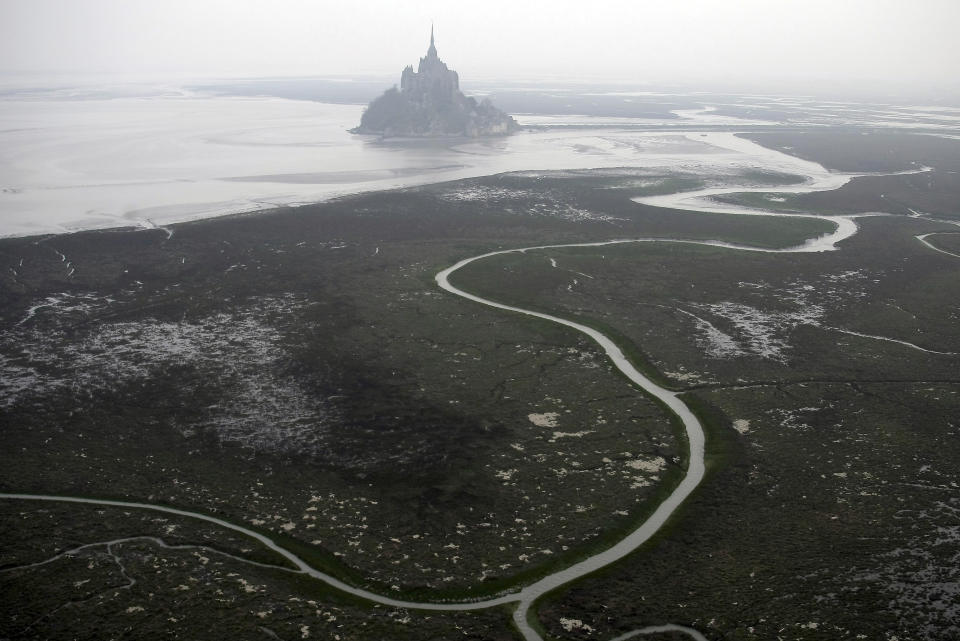 An aerial view of Mont Saint Michel, Normandy, France, on Sunday, March 20, 2011. France’s beloved abbey of Mont-Saint-Michel has reached a ripe old age. It's been 1,000 years since the laying of its first stone. The millennial of the UNESCO World Heritage site and key Normandy tourism magnet is being celebrated until November with exhibits, dance shows and concerts. French President Emmanuel Macron is heading there on Monday, June 5, 2023. (AP Photo/David Vincent)