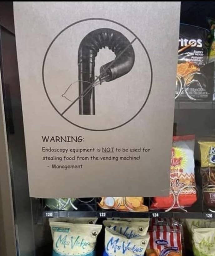 Sign on a vending machine showing an endoscope tool and warning "Endoscopy equipment is NOT to be used for stealing food from the vending machine!"