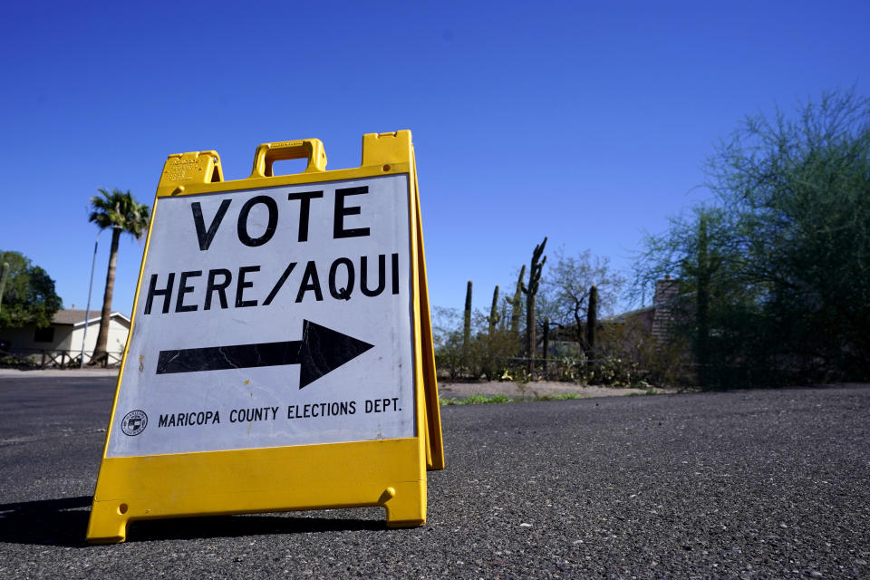 A sign reads: Vote Here/Aqui.