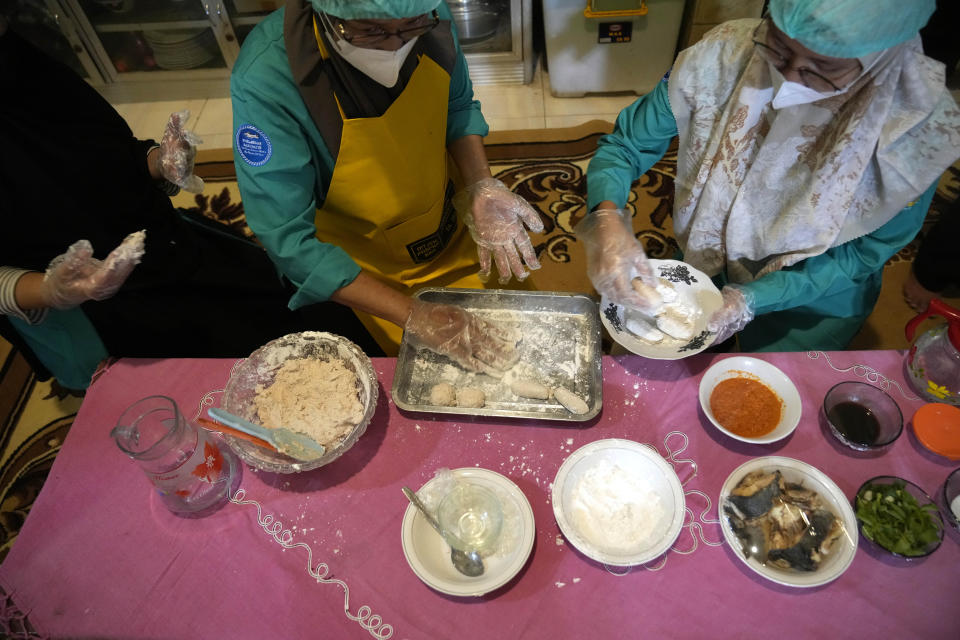 Cooks prepare pempek fish cakes using catfish as the main ingredient in Belitang, South Sumatra, Indonesia, Sunday, July 23, 2023. (AP Photo/Dita Alangkara)