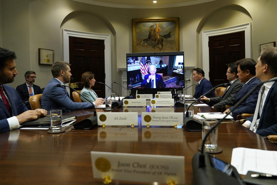 President Joe Biden, on screen at center, participates in a meeting with SK Group Chairman Chey Tae-won, fourth from right, from the Roosevelt Room of the White House in Washington, Tuesday, July 26, 2022. The meeting comes as the Biden administration is seeking the cooperation of Asian allies such as South Korea to reinforce supply chains for critical components such as semiconductors. (AP Photo/Susan Walsh)