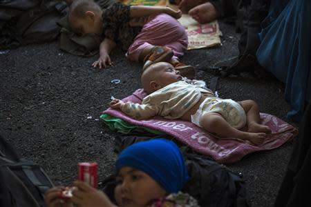 Children of suspected Uighurs from China's troubled far-western region of Xinjiang, rest on a ground inside a temporary shelter after they were detained at the immigration regional headquarters near the Thailand-Malaysia border in Hat Yai, Songkla March 14, 2014. REUTERS/Athit Perawongmetha