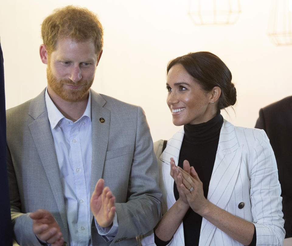 Britain's Prince Harry and his wife Meghan, Duchess of Sussex, clap duirng a lunchtime reception hosted by Australian Prime Minister Scott Morrison with Invictus Games competitors, their families and friends in Sydney Sunday, Oct. 21, 2018. (Paul Edwards/Pool Photo via AP)