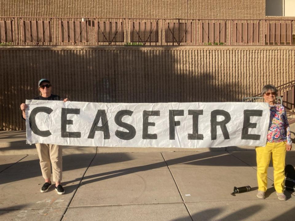 Susanne Distasso and Judith Coborn of the Phoenix Anti-war Coalition hold a sign saying "ceasefire" near Jefferson Street and Randy Johnson Way, near Chase Field for Game 5 of the World Series between Arizona Diamondbacks and Texas Rangers on Wednesday, Nov. 1, 2023.