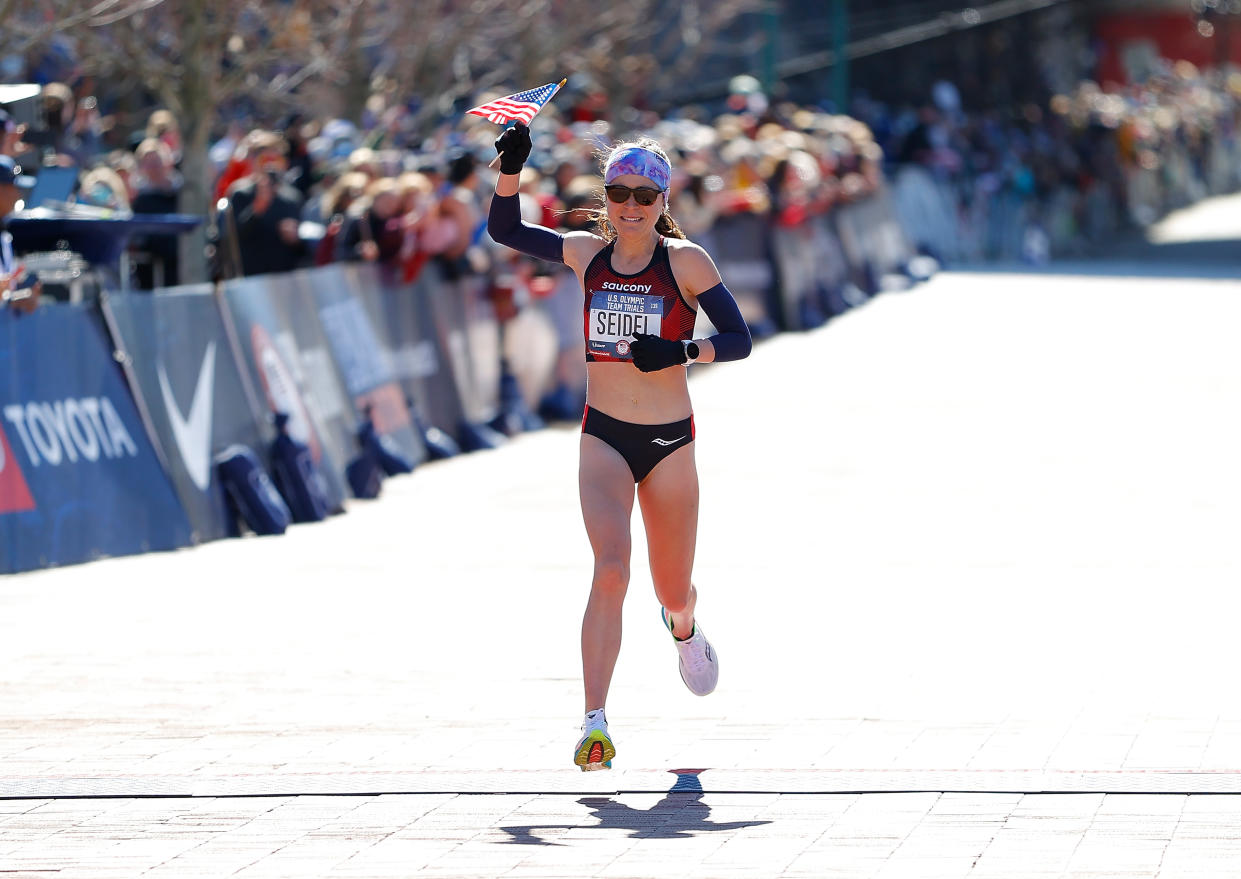 La atleta Molly Seidel cruzando la línea de meta en la carrera clasificatoria para la maratón de los Juegos Olímpicos.