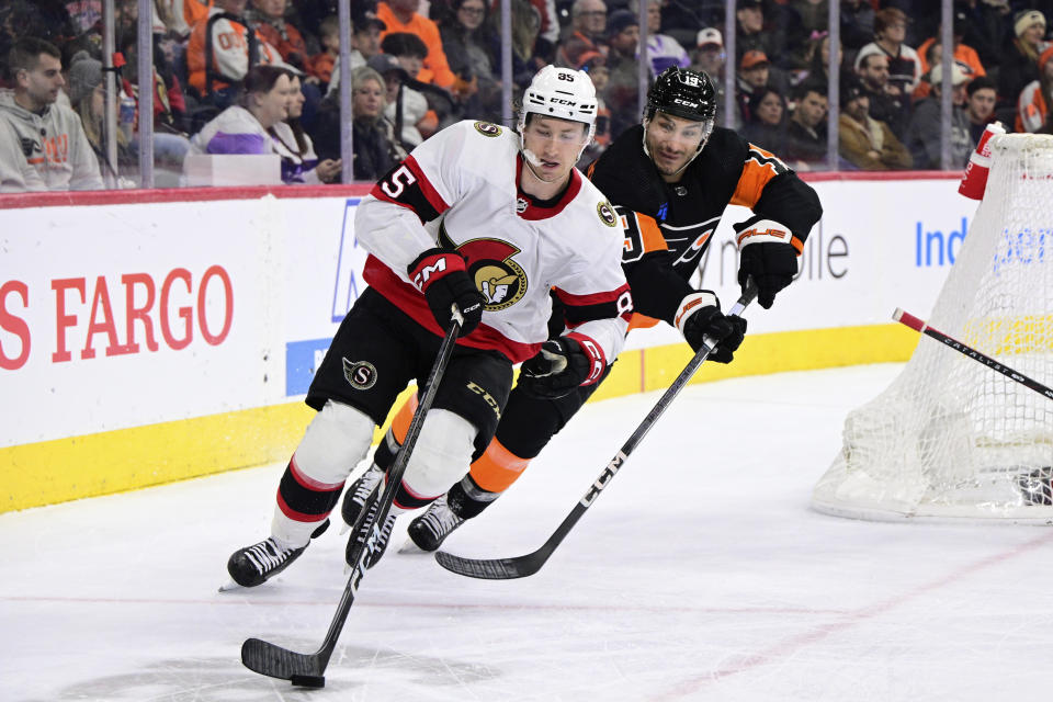 Ottawa Senators' Jake Sanderson skates the puck ahead of Philadelphia Flyers' Garnet Hathaway during the second period of an NHL hockey game, Sunday, Jan. 21, 2024, in Philadelphia. (AP Photo/Derik Hamilton)