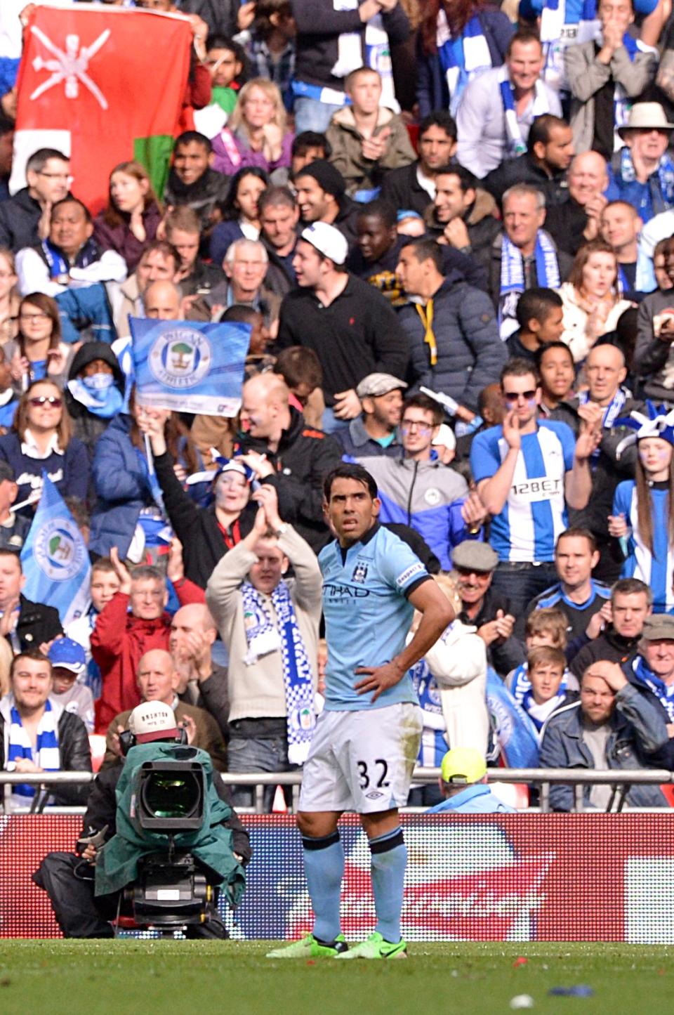 Manchester City's Carlos Tevez stands dejected as he rues a missed chance on goal