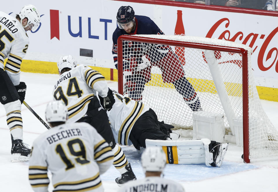 Winnipeg Jets' Gabriel Vilardi (13) scores on Boston Bruins goaltender Jeremy Swayman (1) during the second period of an NHL hockey game Friday, Dec. 22, 2023, in Winnipeg, Manitoba. (John Woods/The Canadian Press via AP)