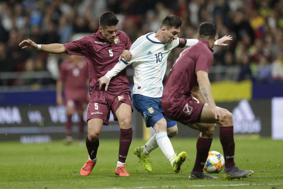 Argentina's Lionel Messi, center, fights for the ball with Venezuela's Junior Moreno, left, and Yordan Osorio, right, during an international friendly soccer match between Argentina and Venezuela at Wanda Metropolitano stadium in Madrid, Spain, Friday, March 22, 2019. (AP Photo/Bernat Armangue)