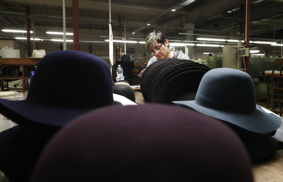 A woman works on hats inside the Borsalino hat factory, in Spinetta Marengo, near Alessandria, Italy, Thursday, Jan. 17, 2019. Borsalino's prized felt hats are handmade by 80 workers in its Piemonte factory, many who have worked there for decades, with original machinery that use hot water and steam to transform rabbit fur into highly prized felt, that is formed into clochards, dyed and molded by hand to create the latest styles. (AP Photo/Antonio Calanni)