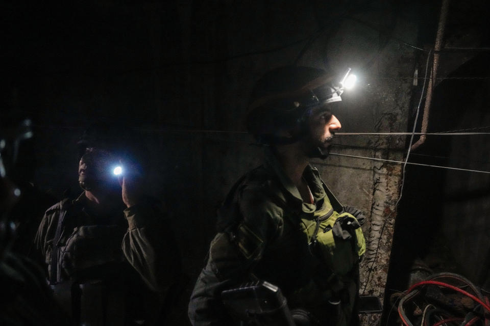 Israeli soldiers are seen in a tunnel that the military says Hamas militants used to attack the Erez crossing in the northern Gaza Strip, Friday, Dec. 15, 2023. The army is battling Palestinian militants across Gaza to retaliate for Hamas' Oct. 7 attack on Israel. (AP Photo/Ariel Schalit)