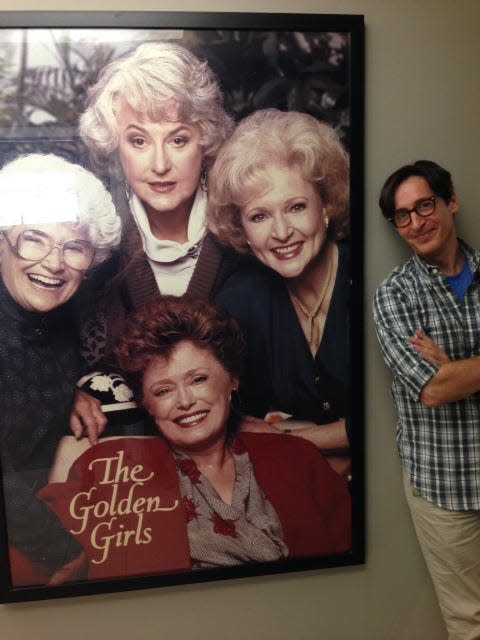 Stan Zimmerman, author of "The Girls: From Golden to Gilmore," poses with a poster featuring the cast of "The Golden Girls," one of several shows he's written for.