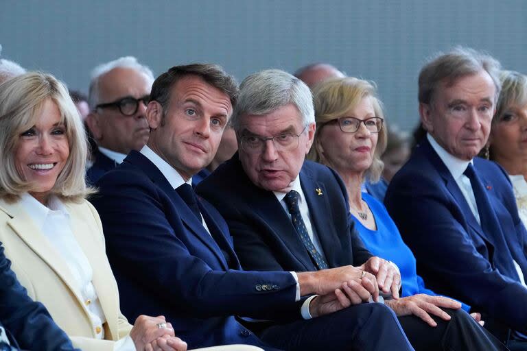 Emmanuel Macron y su esposa Brigitte Macron, junto al presidente del Comité Olímpico Internacional (COI), Thomas Bach, y el CEO de LVMH, Bernard Arnault, en la Fundación Louis Vuitton para una presentación sobre los Juegos Olímpicos, en París. (Thibault Camus / POOL / AFP)