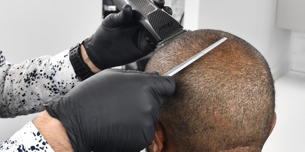 ATLANTA, GEORGIA - MAY 15: Barber Samuel Glickman cuts a client's hair at Privado Grooming Barbershop on May 15, 2020 in Atlanta, Georgia. Georgia Governor Brian Kemp announced that certain businesses including: hair salons, bowling alleys, barbershops and nail salons could reopen on April 24, 2020. There are currently over 36,000 confirmed COVID-19 cases in Georgia.