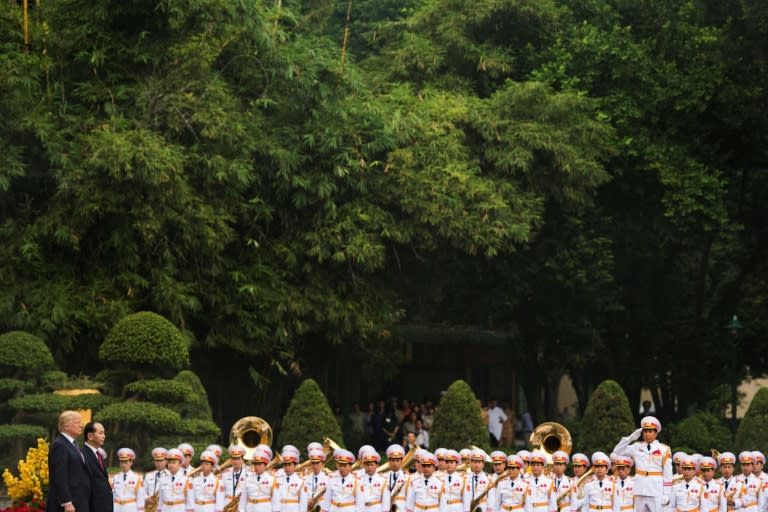 US President Donald Trump, accompanied by his Vietnamese counterpart Tran Dai Quang, observe national anthems during a welcoming ceremony at the Presidential Palace in Hanoi on November 12, 2017