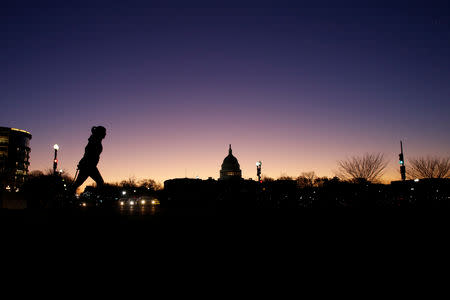 A woman walks by the U.S. Capitol is on day 32 of a partial government shutdown as becomes the longest in U.S. history in Washington, U.S., January 22, 2019. REUTERS/Carlos Barria