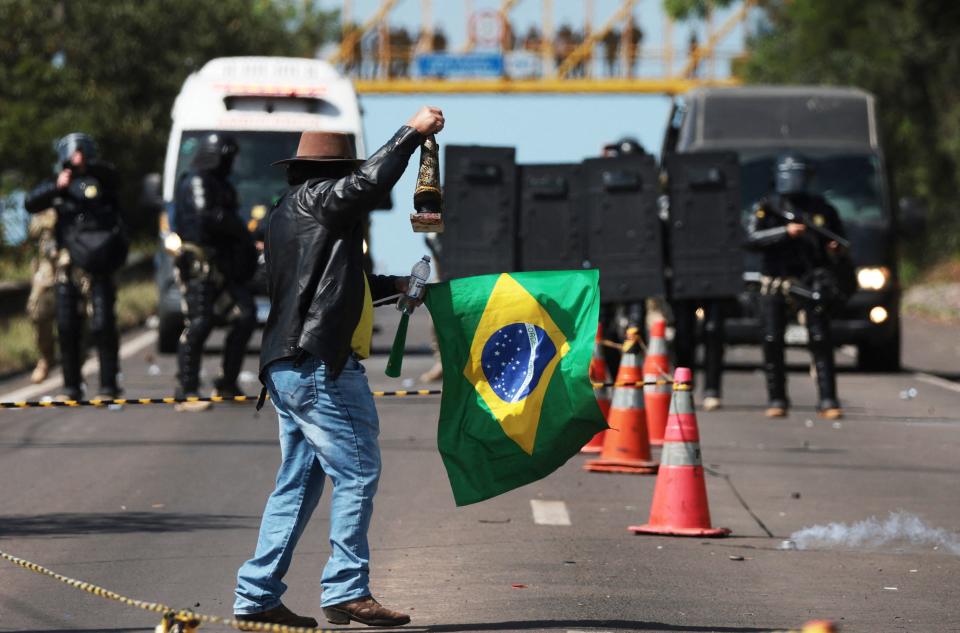 Um apoiador do atual presidente Jair Bolsonaro (PL) em frente a uma tropa de choque da Pol&#xed;cia Militar em Novo Hamburgo (RS), em 1&#xba; de novembro de 2022. Apoiadores do presidente bloquearam rodovias no pa&#xed;s em protestos contra a vit&#xf3;ria de Lula (PT). Desde ent&#xe3;o, posts golpistas inundaram o Facebook(Foto: AFP via Getty Images / Silvio Avila)