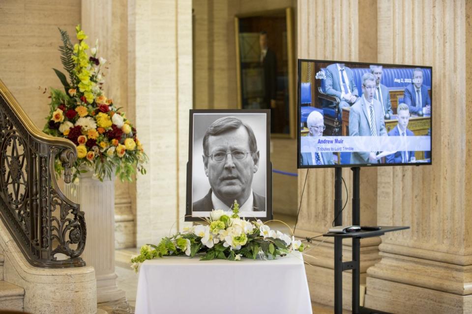 A portrait of former Northern Ireland First Minister and UUP leader David Trimble, who died last week aged 77, rests with flowers in the Grand Hall of Parliament Buildings, as members of the Assembly play tributes (Liam McBurney/PA) (PA Wire)