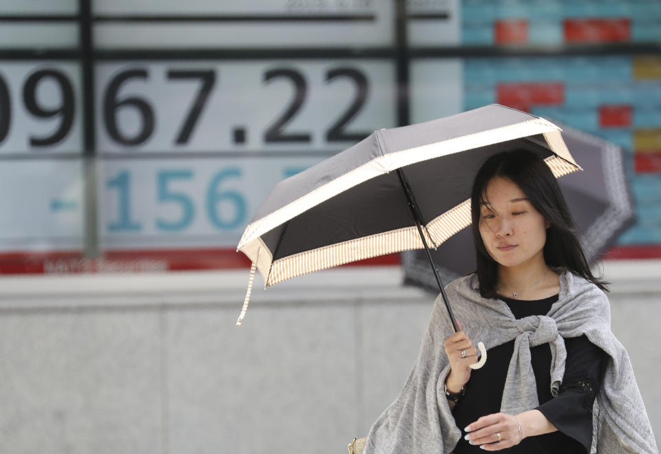 A woman walks by an electronic stock board of a securities firm in Tokyo, Tuesday, June 18, 2019. Stocks in Asia mostly advanced Tuesday ahead of interest rate decisions by the U.S. Federal Reserve and other central banks. (AP Photo/Koji Sasahara)